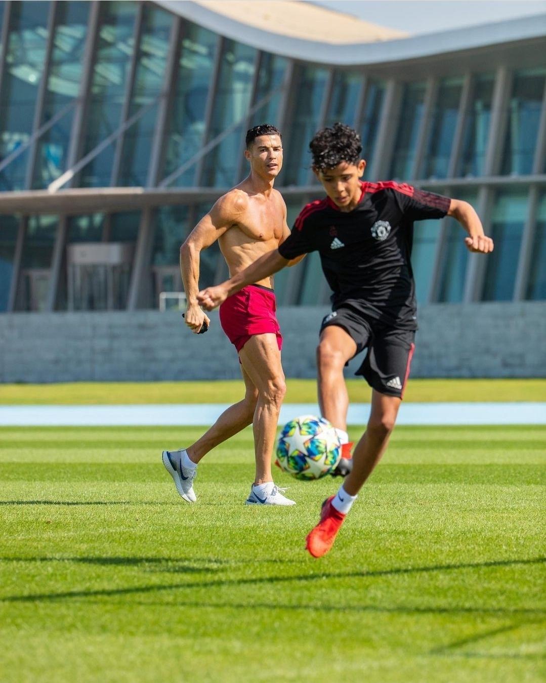 Dois jogadores de futebol jogando futebol no campo marcando um