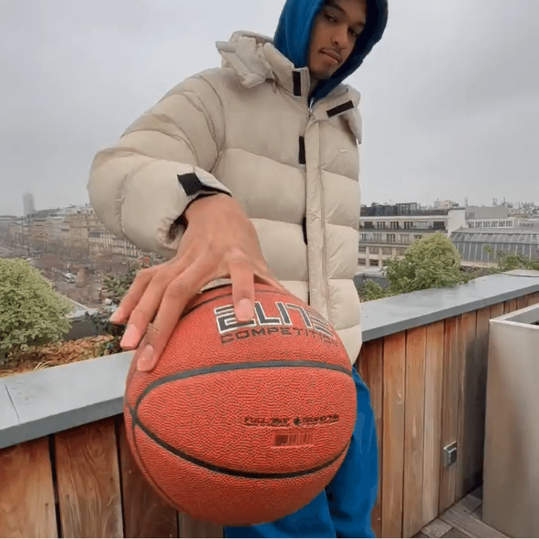 Jogador de homem feliz joga bola de basquete através da vitória na