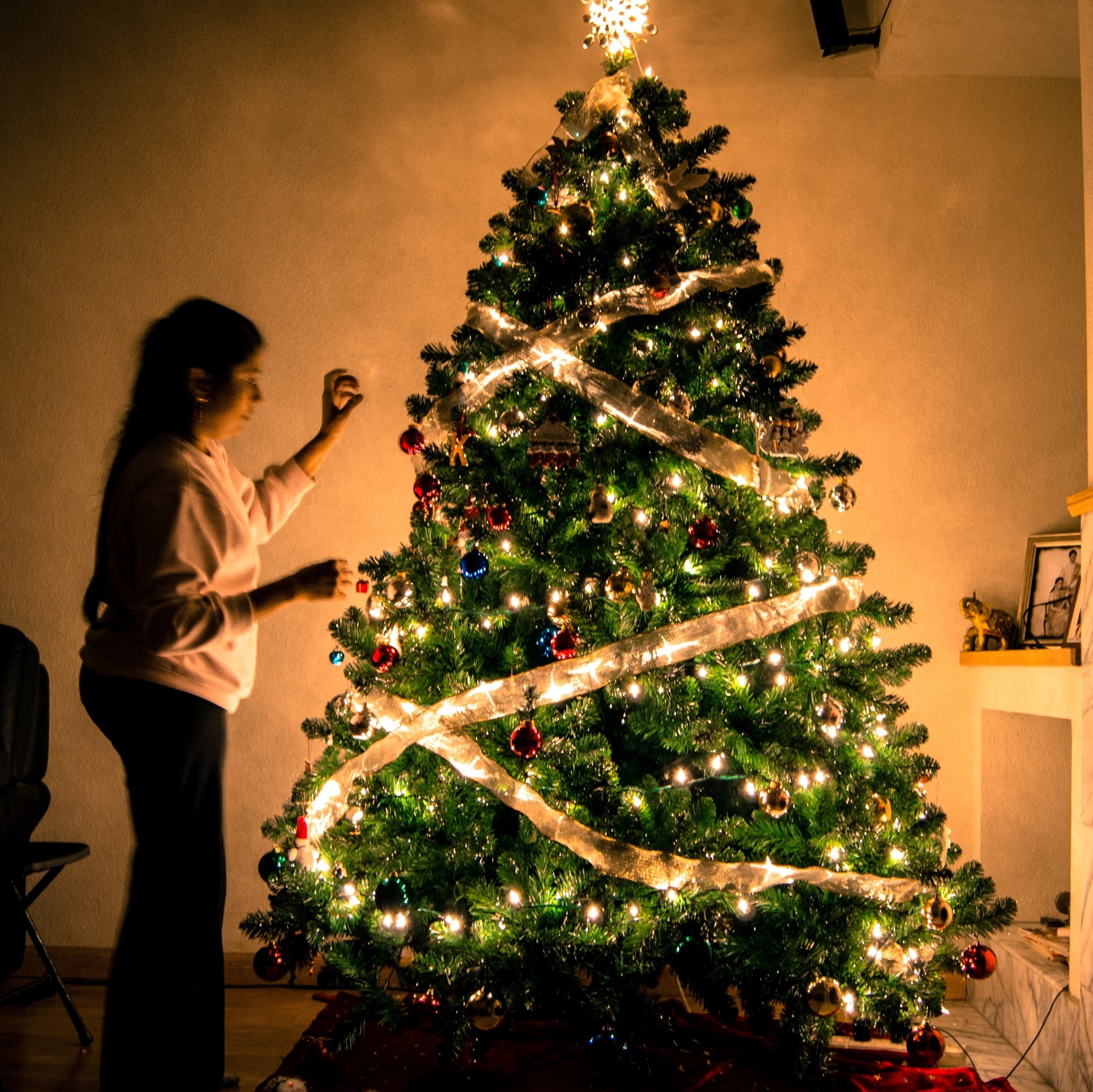 Sala de estar de natal branca e dourada com árvore de natal e