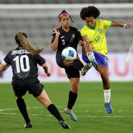 Aline (Brasil) e De Jesus (Porto Rico) disputam a bola em jogo da Copa Ouro Feminina