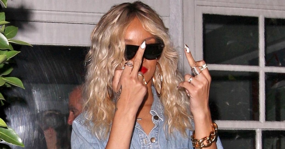 Irritada com a presença de fotógrafos,Rihanna mostrou os dedos médios, em sinal de insulto, enquanto jantava no restaurante Giorgio Baldi em Santa Mônica, na Califórnia (EUA) (23/3/12)