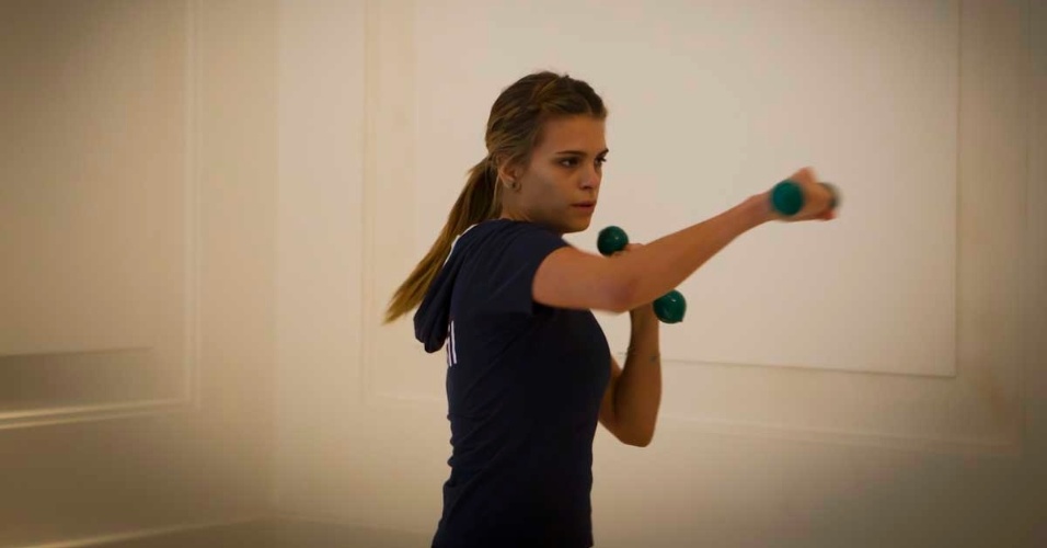 A amazona Luiza Almeida simula golpes de boxe com pesos de academia