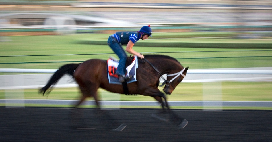 Joquei galopa durante treino pela manhã, para a 17ª Copa do Mundo de Corrida de Cavalos, na pista Meydan em Dubai