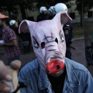 Manifestante com máscara de porco protesta perto da embaixada alemã em Atenas, na Grécia, contra medidas de austeridade tomadas pelo governo