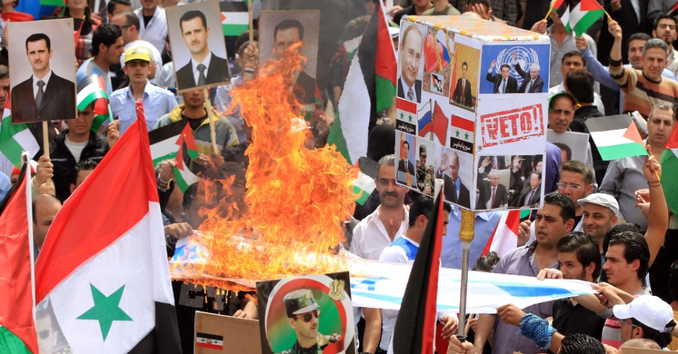 Sírios queimam bandeira de Israel e agitam bandeiras do Baath, em comemoração do aniversário do partido em Damasco