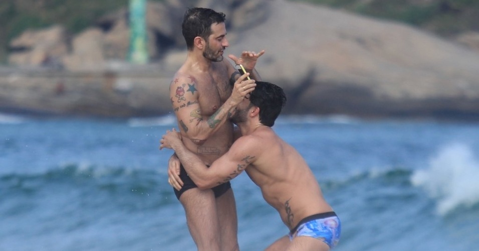 Harry Louis (dir) abraça Marc Jacobs (esq) na praia de Ipanema, zona sul do Rio (9/4/2012)
