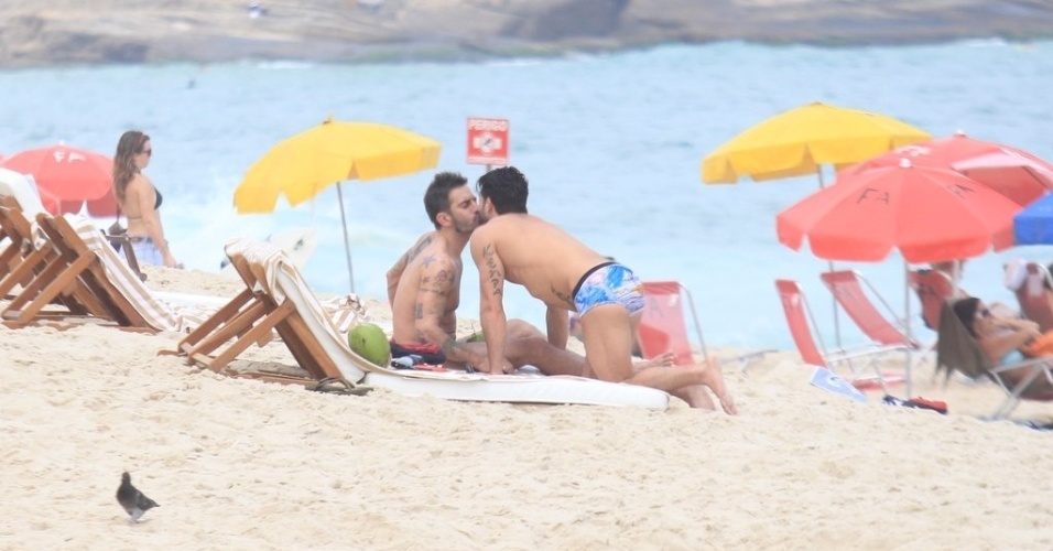 O estilista americano Marc Jacobs (esq) troca beijos com o namorado, o ator pornô brasileiro Harry Louis (dir), na praia da Ipanema, zona sul do Rio (9/4/2012)