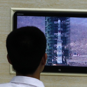 Cientista norte-coreano observa monitor com imagens do foguete Unha-3 em sala de controle de satélites