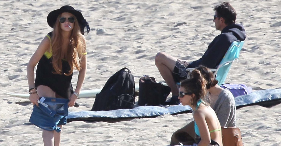 Com cigarro na boca, atriz Lindsay Lohan passa a tarde na praia de Malibu, na Califórnia (EUA), ao lado da irmã, Ali, e dos amigos. Após cumprir pena, Lindsay aproveita sua liberdade desde o último dia 29 de março (10/4/12)