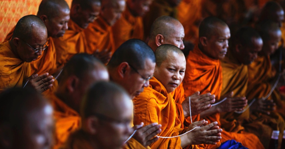 Monges budistas se juntam a familiares e amigos dos membros mortos do movimento "camisa vermelha" durante oração em Bangcoque