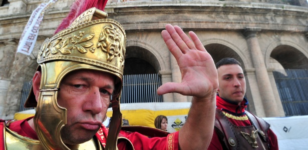 Homens fantasiados de gladiadores romanos que trabalham nas proximidades do Coliseu de Roma - Alberto Pizzoli/AFP