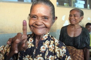 Mulher mostra o dedo marcado após votar no Timor Leste. Foto de 16/04/2012