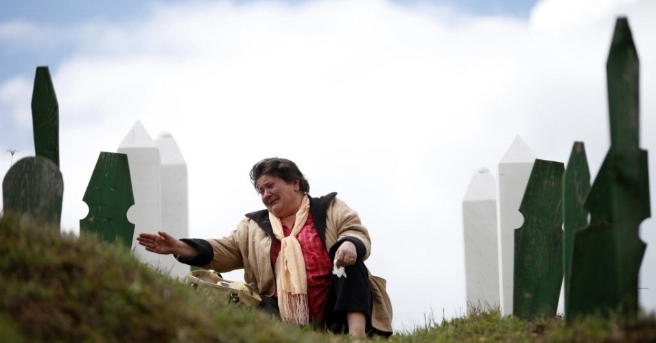 Muçulmana chora em frente a túmulo de parentes na cidade de Vlasenica, na parte sérvia da Bósnia-Herzegóvina 