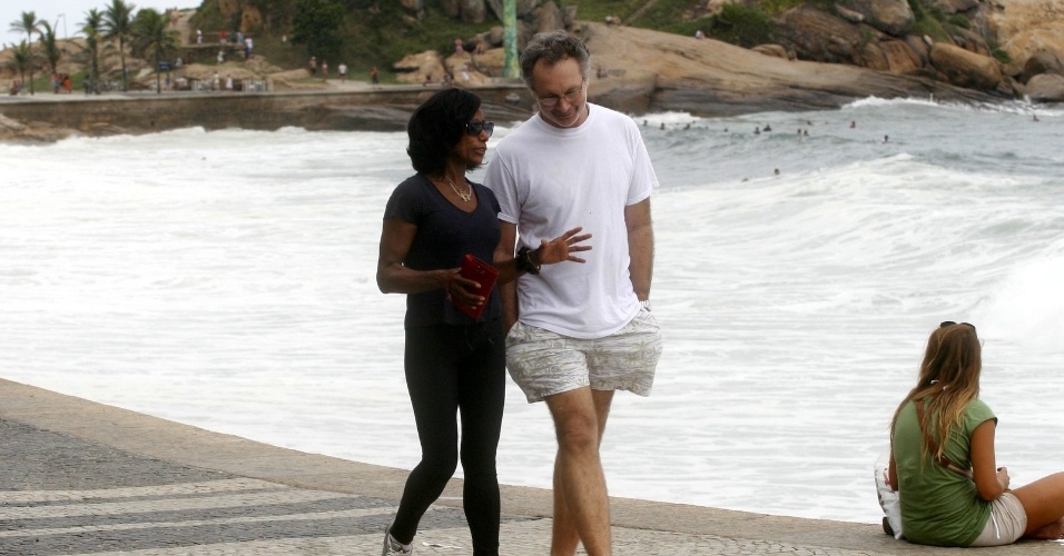 A jornalista Glória Maria caminha acompanhada de um amigo pela orla da praia do Arpoador, zona sul do Rio (23/4/12)
