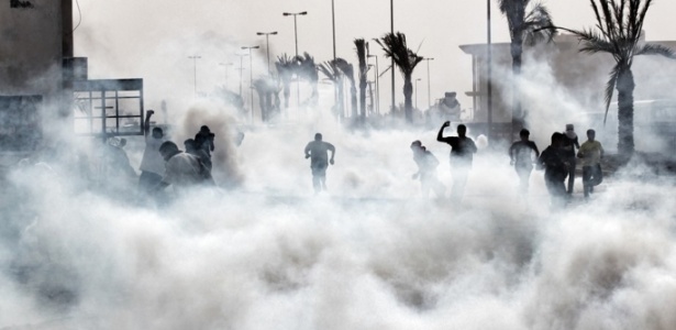 Manifestantes são atingidos por gás lacrimogêneo lançado pela polícia durante protesto no Bahrein - 23.abr.2012 - AFP