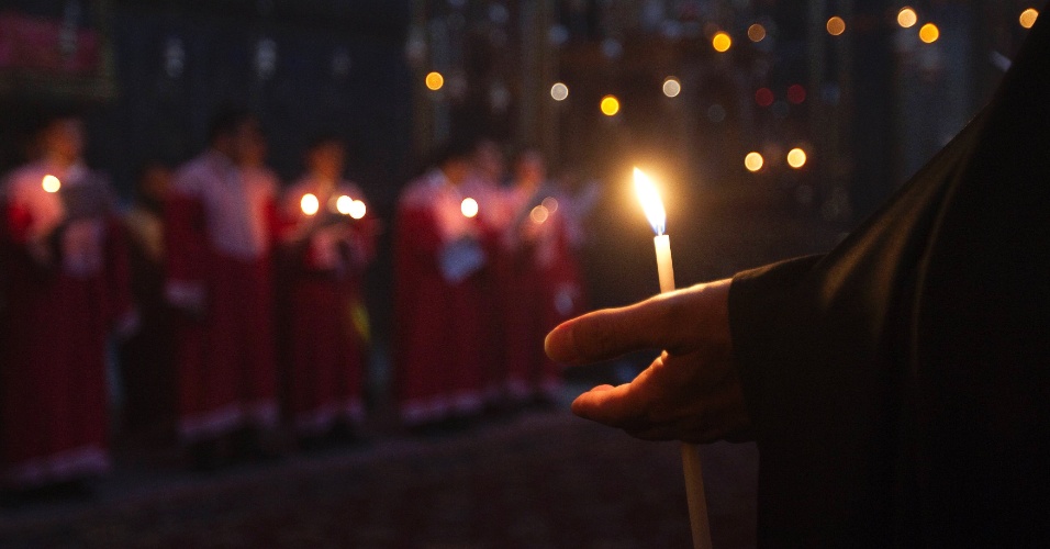 Membro do clero armênio com uma vela durante oração especial pelo aniversário do assassinato em massa de armênios no Império Otomano em 1915, em Jerusalém
