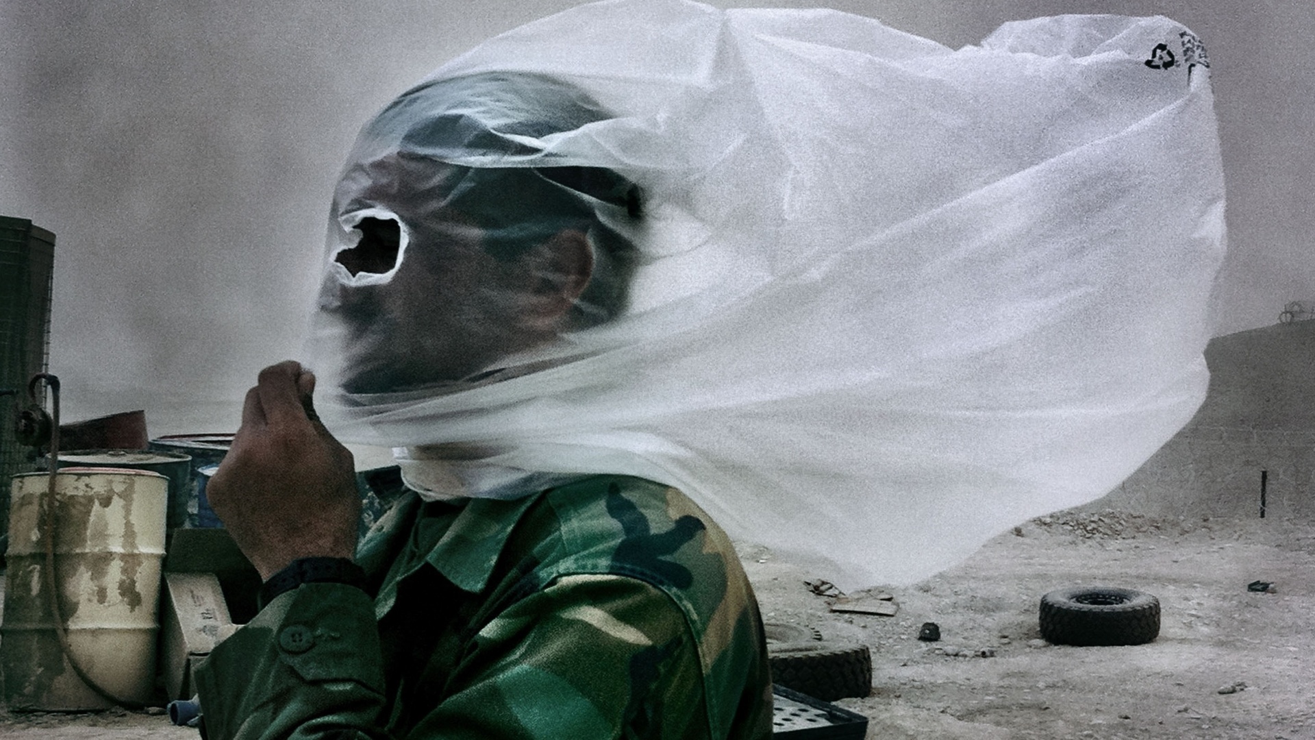 Detalhe de foto ícone do trabalho de Balazs mostra um soldado afegão com um saco plástico na cabeça durante tempestade de areia causada por um combate (28/10/2010)  - BalazsGardi/Basetrack.org