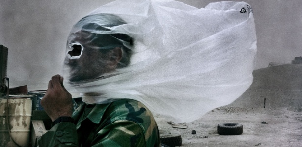 A foto ícone do trabalho de Balazs mostra um soldado afegão com um saco plástico na cabeça durante tempestade de areia causada por um combate (28/10/2010)  - BalazsGardi/Basetrack.org