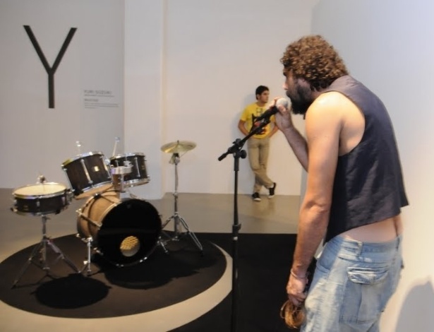 Visitante testa obra do britânico Yuri Suzuki. Na instalação, uma bateria é controlado pelos sons emitidos no microfone - Divulgação