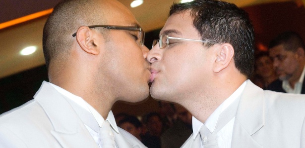 Fundador de uma igreja LGBT, Marcos Gladstone (à dir.) beija seu parceiro, Fábio Inácio - BBC  