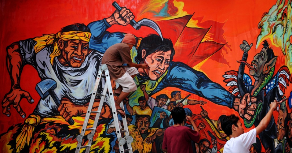 Filipinos dão os últimos retoques em um mural que será usado no Dia do Trabalho, em Manila 