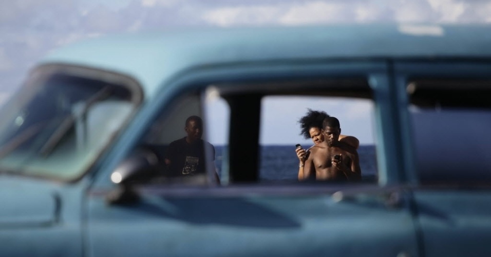 Casal namora no Malecón, o calçadão à beira-mar em Havana, capital de Cuba