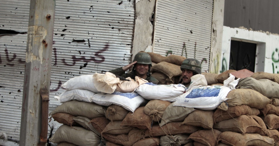 Soldados sírios ficam atrás de posto de segurança feito de sacos de areia no bairro de Bab Amro, na periferia de Homs