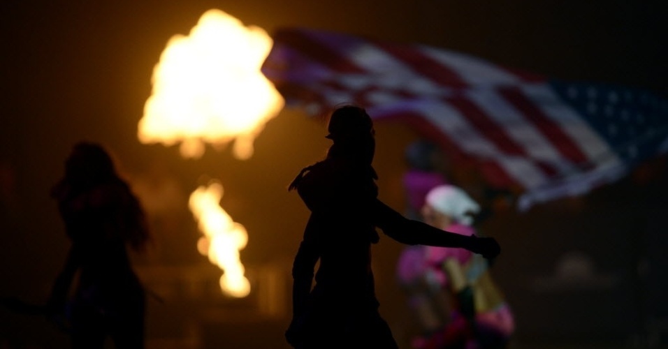 Jogadora carrega a bandeira americana ao témino da partida, na Cidade do México