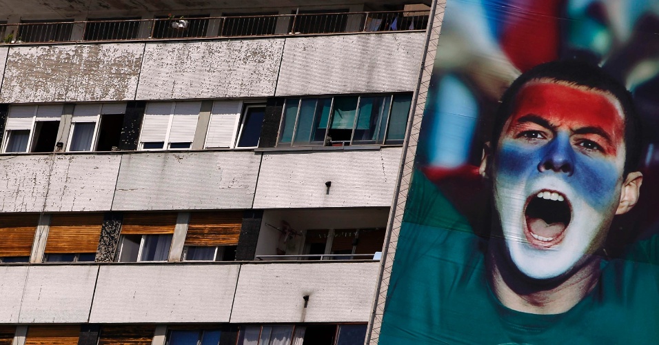7.mai.2012 - Outdoor gigante com uma foto de um homem com o rosto pintado com as cores da bandeira da Sérvia é visto do lado de um prédio antigo, em Belgrado, na Sérvia