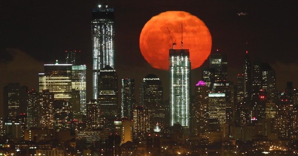 7.mai.2012 - A lua cheia vista do West Orange, Nova Jersey, se eleva sobre o horizonte de Manhattan e One World Trade Center (Esq.), em Nova York