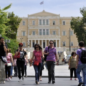 Pessoas caminham em frente ao prédio do Parlamento grego em Atenas