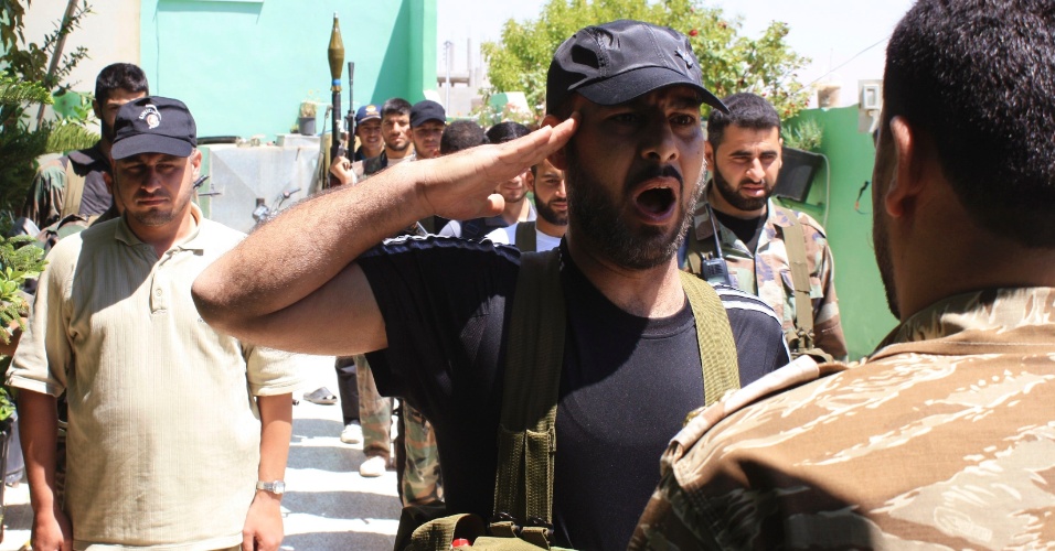 8.mai.2012 - Combatente do Exército sírio faz continência para superior durante treinamento em Quseir, cidade no norte da Síria