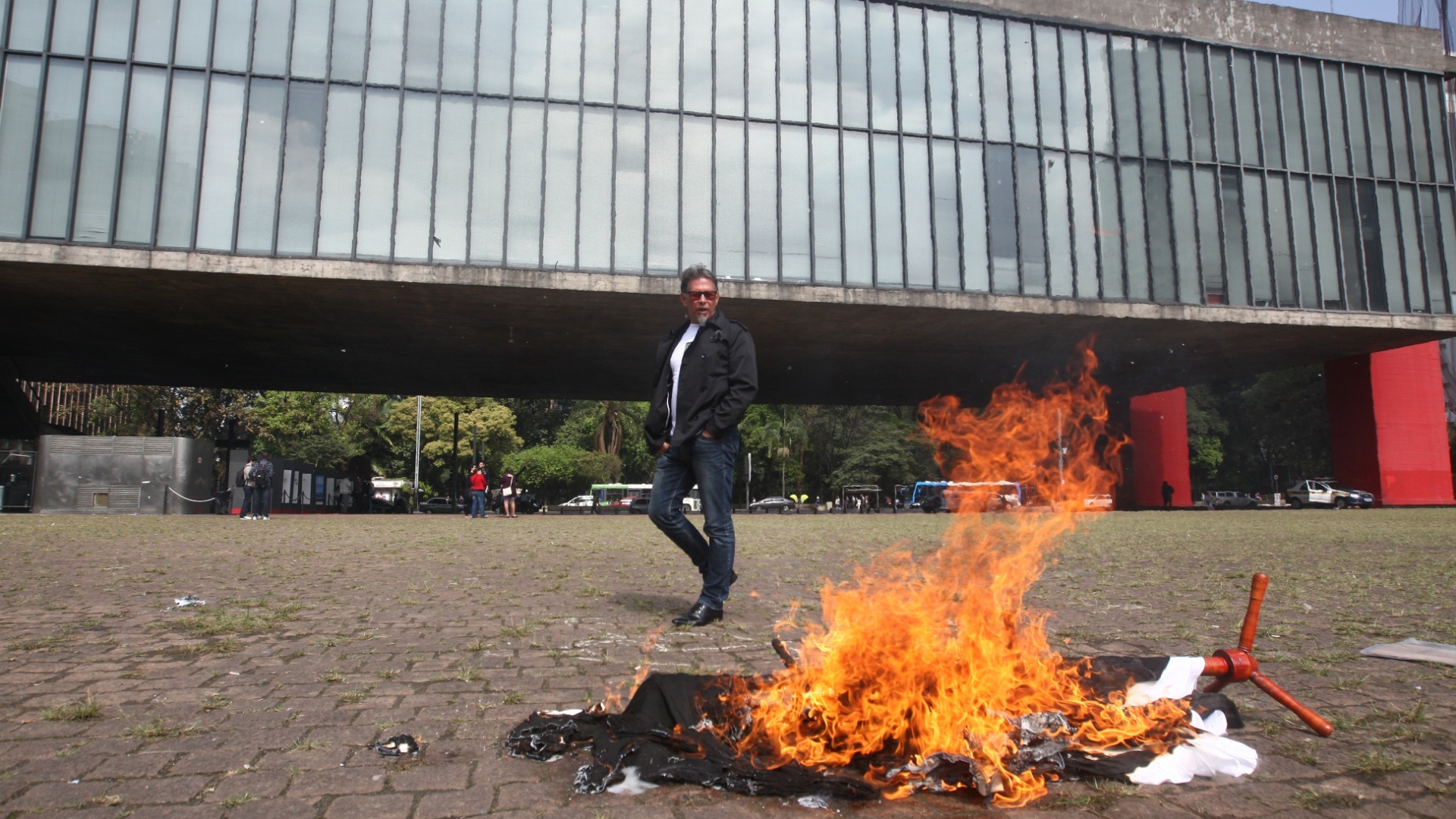 10.mai.2012 - Homem ateia fogo às roupas dele da marca Zara no vão do Mascp, em São Paulo, em protesto contra o trabalho escravo envolvido na produção das roupas da loja - André Vicente/Folhapress
