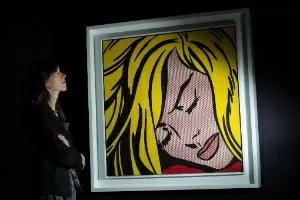 Mulher observa quadro "Sleeping Girl" de Roy Lichtenstein na Sotheby"s, em Londres (9/5/12) - AFP/ Carl Court