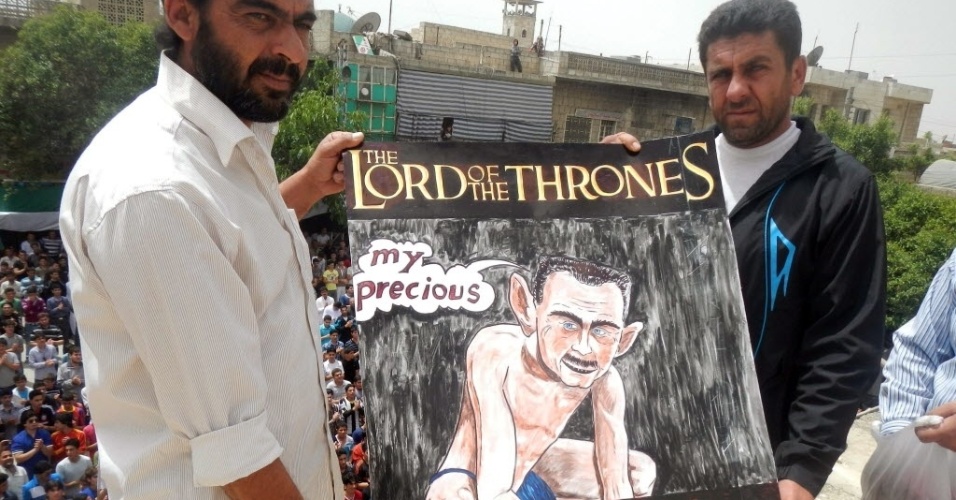 12.mai.2012-Manifestantes sírios exibem cartaz de caricatura de Assad como personagem de Senhor dos Anéis
