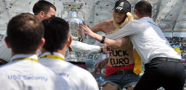 Segurança detém ativista do grupo ucraniano Femen, que atua pelos direitos das mulheres, quando ela tentava se aproximar da taça da Eurocopa 2012, em evento em Kiev, no último dia 12. O grupo protestou contra a expectativa de aumento da prostituição durante o campeonato - Sergei Supinsky/AFP