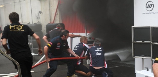 Funcionários das equipes de F-1 tentam apagar o incêndio nos boxes da Williams - AFP PHOTO / DIMITAR DILKOFF