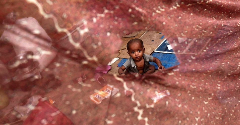 14.mai.2012 - Uma criança, cujos pais dizem pertencer à Comunidade Rohingya birmanês de Mianmar, dentro de um abrigo improvisado em um campo em Nova Delhi