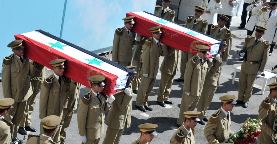 15.mai.2012 - Militares sírios carregam caixões de soldados, durante cerimônia de funeral, em Damasco