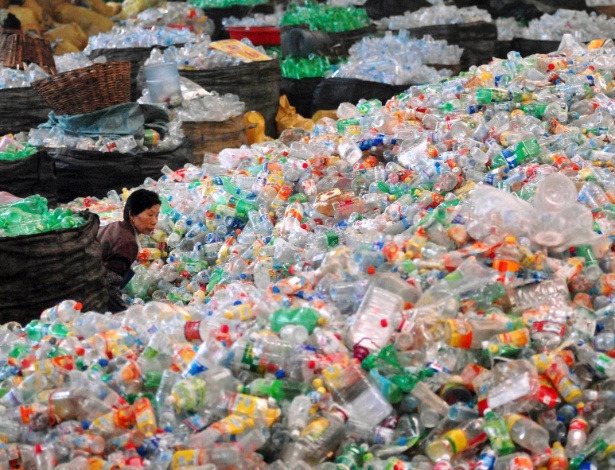 Trabalhadora caminha entre embalagens plásticas em centro de reciclagem em Jiangsu, na China - Leo Lang/Reuters