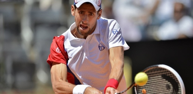 Novak Djokovic tenta rebater a bola de Juan Monaco em Roma - AFP PHOTO / Filippo MONTEFORTE