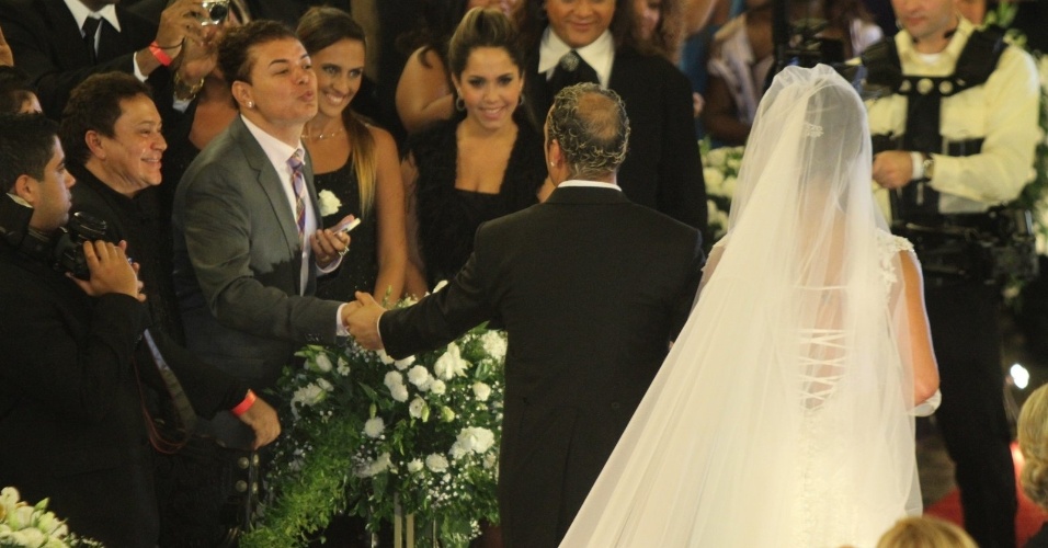 Animado, o promoter David Brazil manda beijinhos em cumprimento ao noivo Belo na saída da Igreja da Candelária (18/5/2012)