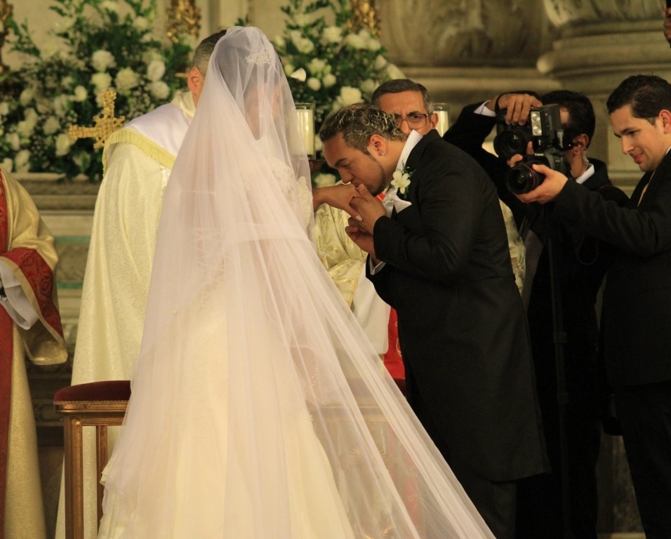 Belo beija a mão da noiva depois da troca de alianças com a noiva Gracyanne Barbosa
