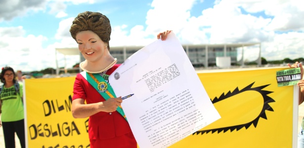 Homem vestido com fantasia da presidente Dilma Rousseff participa de protesto contra o Código Florestal em frente ao Palácio do Planalto. Ele simulou a assinatura do veto ao texto pela presidente - Reuters/Ueslei Marcelio