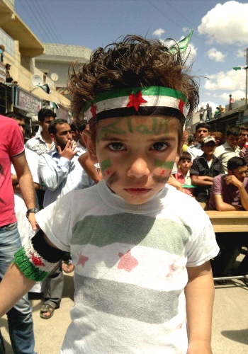25.mai.2012 - Menino participa de protesto contra o ditador sírio, Bashar al Assad, em Maraa, perto de Aleppo, no norte da Síria. O ato ocorreu após as tradicionais orações das sextas-feiras
