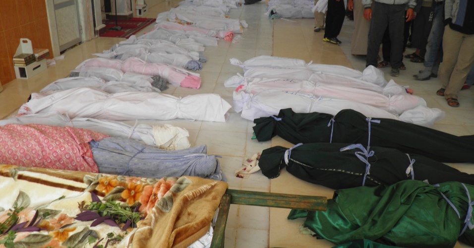 Imagem divulgada neste sábado (26) de corpos enfileirados na cidade de Hula, que ativistas da oposição na Síria dizem ser das vítimas de um ataque das forças do governo que teria matado 90 pessoas