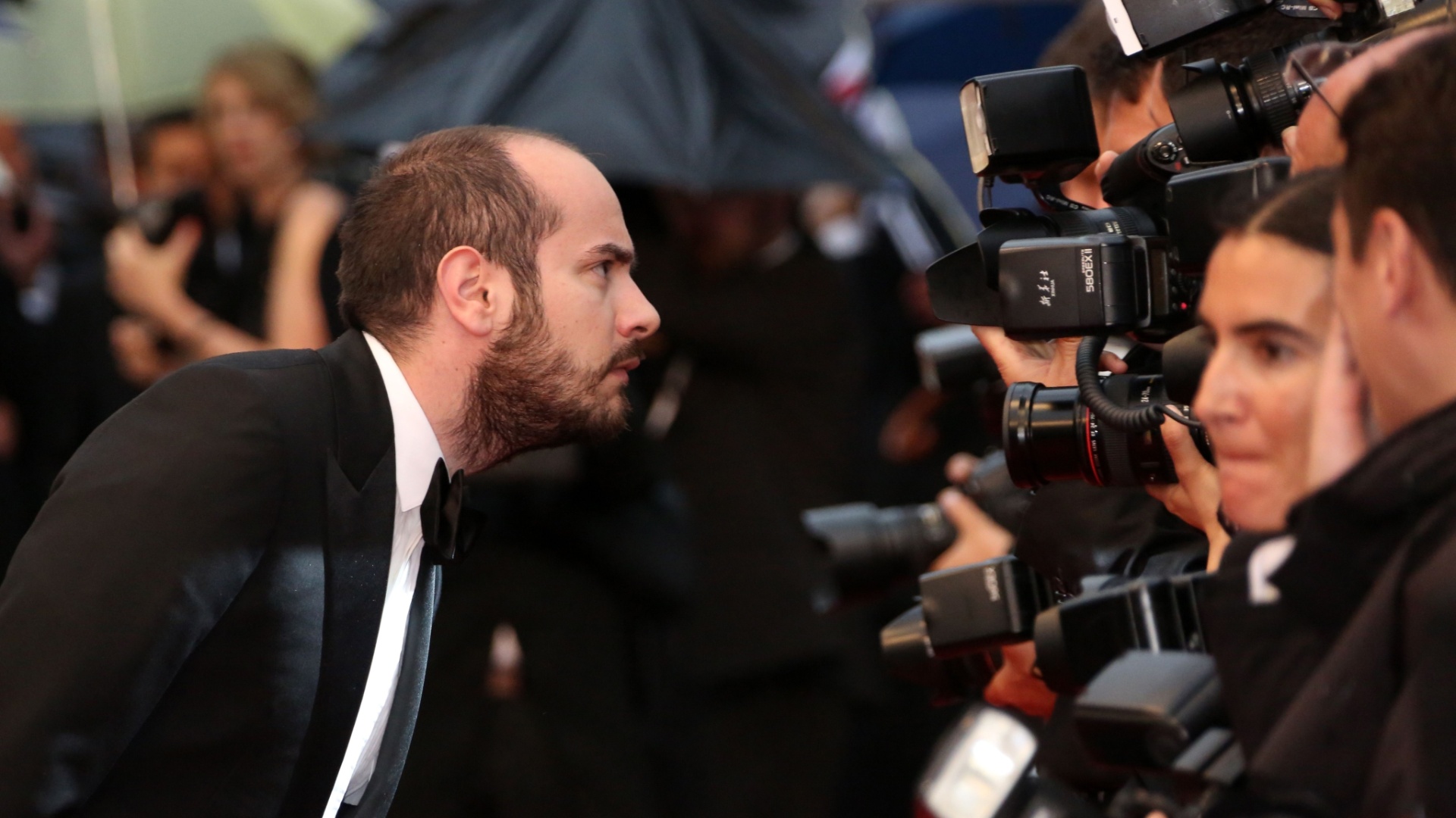 O escritor do discurso da cerimônia de encerramento, Kyan Chojandi observa os fotógrafos em sua chegada a cerimênia de encerramento do Festival de Cannes, na França (27/5/12)  - Loic Venance/ AFP Photo
