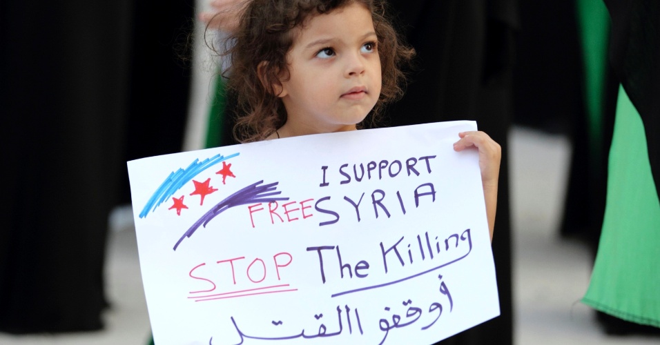 Os demais países árabes se solidarizam à causa dos militantes antigoverno na Síria. ?Sou a favor da liberdade na Síria. Chega de mortes?, diz o cartaz da criança durante protesto em Manama, no Bahrein