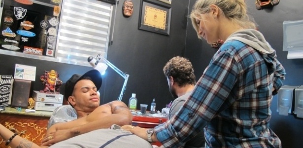29.mai.2012 - Ao lado da noiva, a modelo Dani Souza, Dentinho, jogador do Shakhtar Donetsk, esteve em um estúdio para fazer uma tatuagem no braço