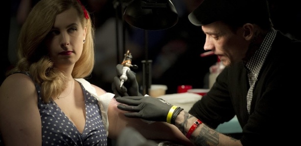 Mulheres se tatuam durante a 15ª Convenção de Tatuagem na cidade de Manhattan, em Nova York (19/5/2012) -  AFP PHOTO / MLADEN ANTONOV